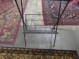 a glass table with a magazine rack on it in the middle of a room