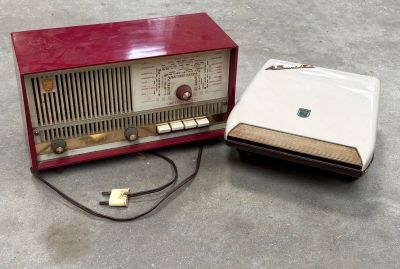 une radio rouge posée par terre à côté d'un ordinateur portable