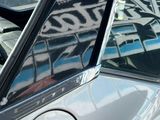 le reflet d'un bâtiment dans la vitre d'une voiture