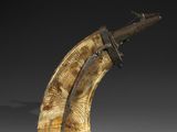 a close up of a wooden object with a knife on it