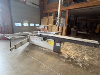 une grosse machine qui scie du bois dans un bâtiment
