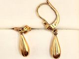 deux paires de boucles d'oreilles dorées sur fond blanc