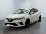 Une voiture blanche est garée dans une pièce au sol noir.