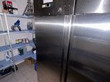 a large stainless steel refrigerator in a kitchen next to shelves