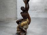 statue d'une femme tenant un panier sur la tête dans une pièce