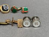 a pair of cufflinks and a pair of cufflinks sitting on a table