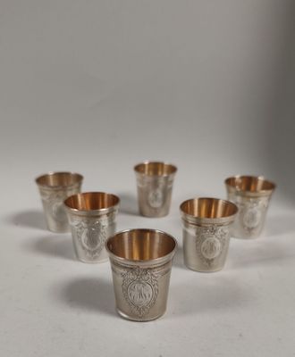 six coupes en argent ornées de motifs, posées sur une surface blanche