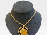 un mannequin noir orné d'un pendentif en forme de soleil doré