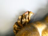 une statue en or représentant une femme tenant une fleur