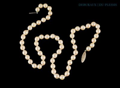 un ensemble composé d'un collier et de boucles d'oreilles en perles blanches sur fond noir