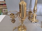 a table with a lamp, a candle holder and a vase on it