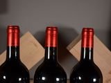 three bottles of red wine in a wooden box