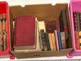 trois cartons de livres sont empilés sur une étagère dans une pièce