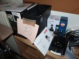 a cell phone sitting on top of a desk next to a printer