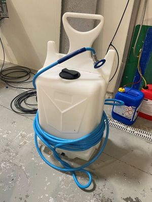 un récipient blanc muni d'un tuyau bleu et d'une poignée bleue