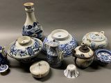 many blue and white vases and other items on the table