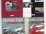 trois livres posés sur une table blanche, avec une couverture rouge et une voiture en noir et blanc