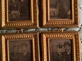 four antique photo frames of a man and a woman and a dog