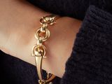 the woman is wearing a black sweater and a gold bracelet