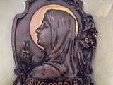 statue of a woman with a veil on a plaque on a wall