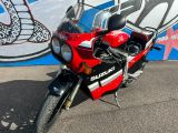 une moto rouge garée devant une fresque murale