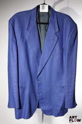 une veste de costume bleue suspendue à un cintre sur un mur blanc