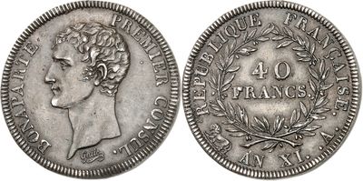 a silver coin with a woman ' s head and laurels on it