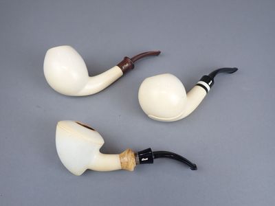 deux porte-pipes posés l'un à côté de l'autre sur une table