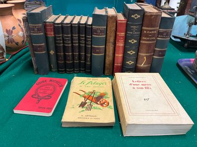 Plusieurs livres sont posés sur une table recouverte d'un tissu vert.