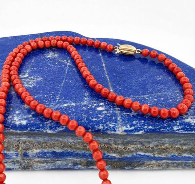beaded necklace with red coral beads and a silver clasp