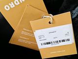 two tags attached to the back of a black jacket
