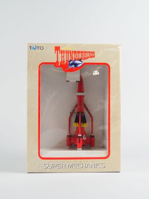 un petit avion rouge dans une boîte posée sur une surface blanche