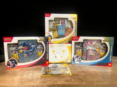 three boxes of pokemon toys sitting on top of a wooden table