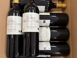 six bouteilles de vin dans un carton sur la table