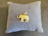 un petit éléphant en or posé sur un oreiller