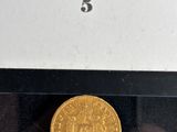 an image of a gold coin sitting on top of a black table