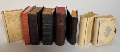 several old books are lined up in a row on a table