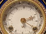 a blue and gold clock that is on a table