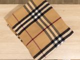 a burberl and black checkered scarf on a wooden table