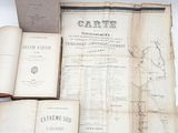 an old book with a map on top of it sitting on a table