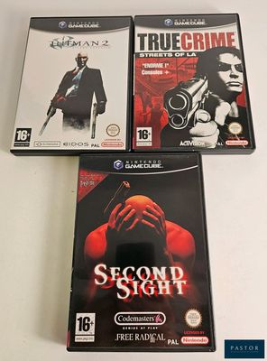 three video games are sitting on a table with a white background