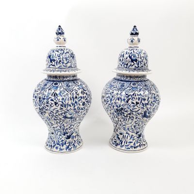 two blue and white vases sitting next to each other