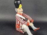 a toy soldier sitting on a chair with his legs crossed