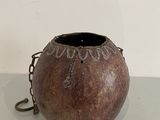 a brown vase with a chain around it on a table