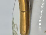 an image of a close up of a gold handle on a white vase