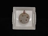 a small white plate with a small brown object in it