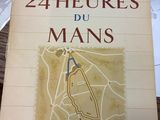 une personne tenant un livre sur lequel figure une carte, posé sur une table