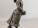 bronze figurine of a girl with a basket of flowers