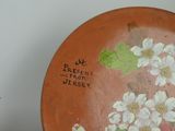 a plate with flowers painted on it on a table