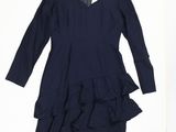Cette robe a des manches longues et un ourlet à volants.